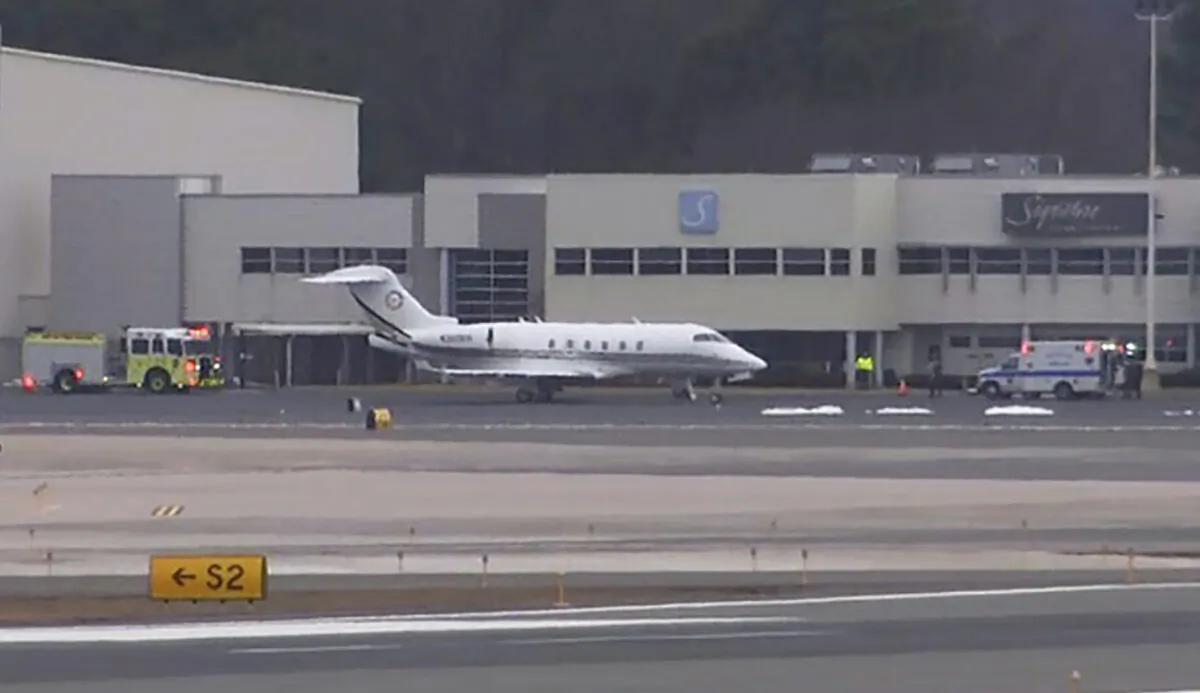 Emergency vehicles flank a Bombardier Challenger 300 that diverted to Bradley International Airport in Windsor Locks, Conn., on March 3, 2023. Investigators said on March 24 that a passenger on a business jet was fatally injured in early March when the aircraft violently bucked up and down after pilots disconnected a system used to stabilize the plane. (NBC Connecticut via AP)