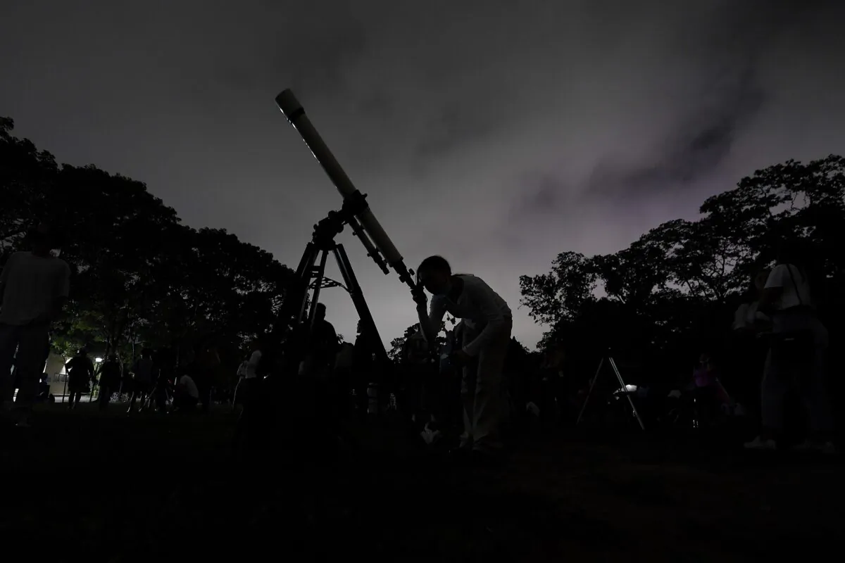 A girl looks at the moon through a telescope in Caracas, Venezuela, on May 15, 2022. (Matias Delacroix/AP Photo)