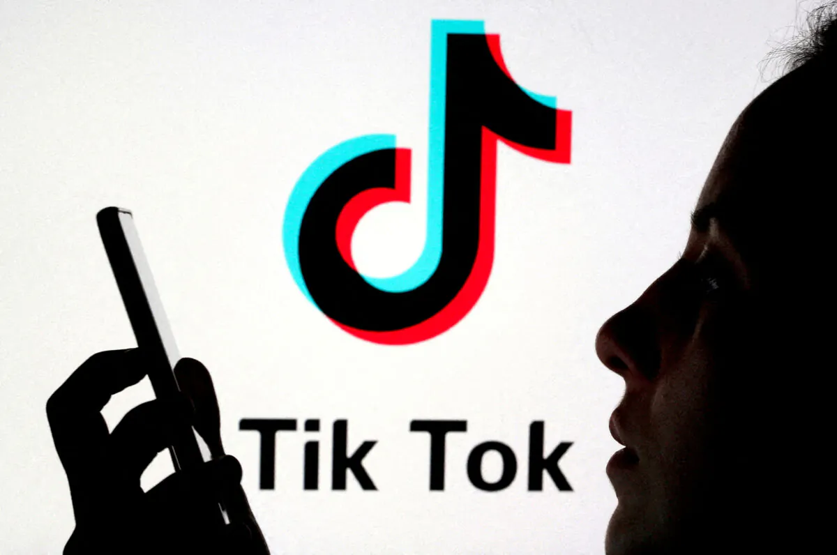 A person holds a smartphone as Tik Tok logo is displayed behind in this picture illustration taken on Nov. 7, 2019. (Dado Ruvic/Reuters)