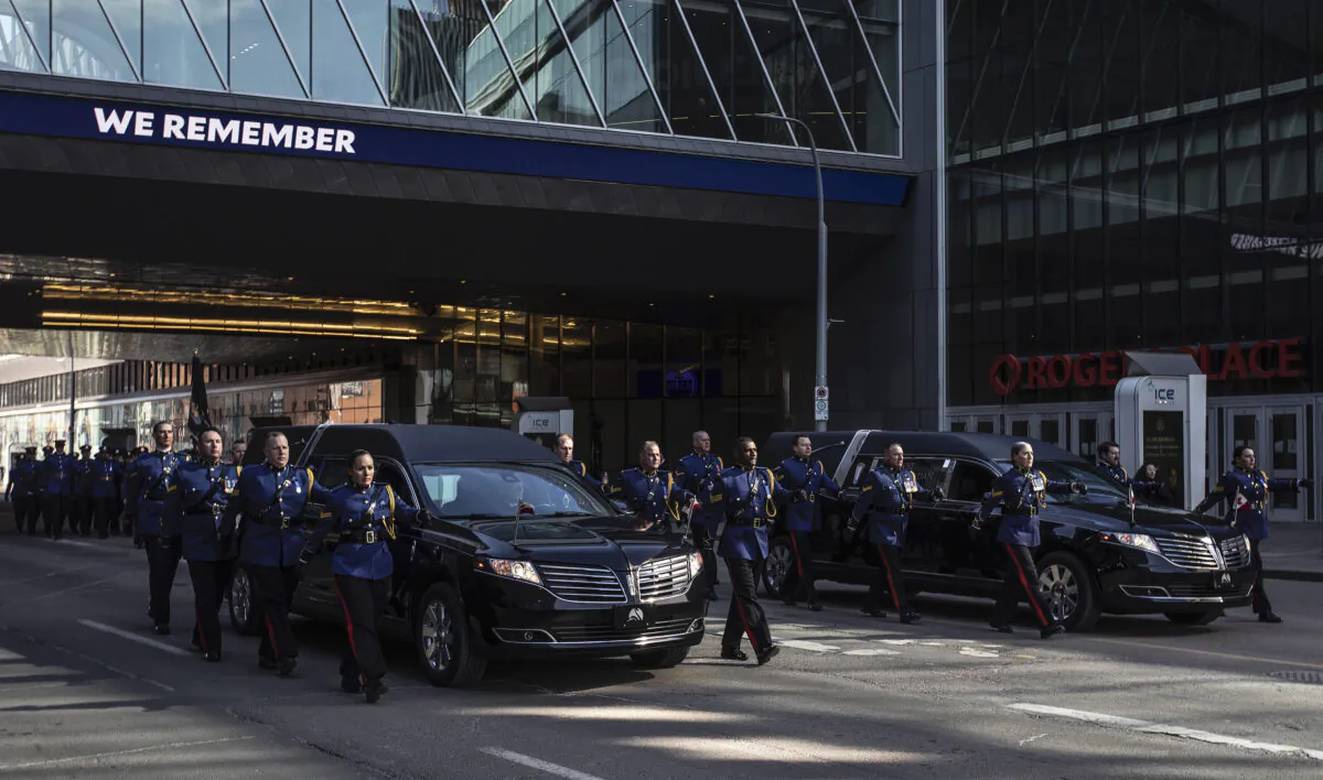 Police march along side the hearses during the procession for Edmonton Police Service constables Travis Jordan and Brett Ryan in Edmonton, March 27, 2023. The officers were killed in the line of duty on March 16, 2023. (The Canadian Press/Jason Franson)