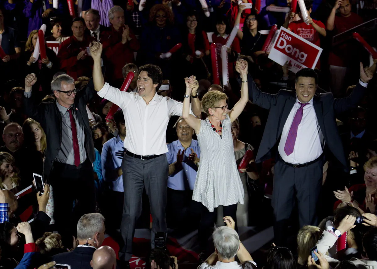 (L–R) Federal candidate Adam Vaughan, Liberal Leader Justin Trudeau, Ontario Premier Kathleen Wynne, and provincial candidate Han Dong celebrate with supporters while taking part in a rally during a campaign stop in Toronto on May 22, 2014. (The Canadian Press/Nathan Denette)