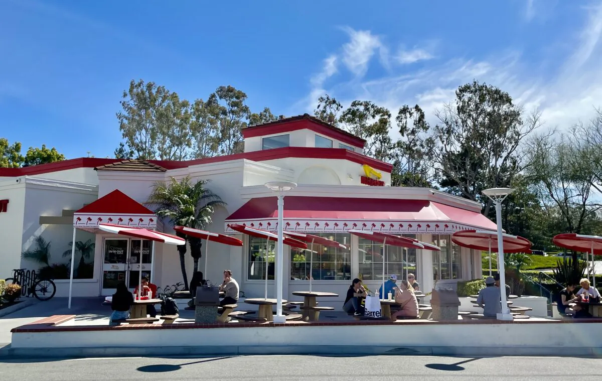 People are seen enjoying meals sitting outside of the In-N-Out. (Sophie Li/The Epoch Times)