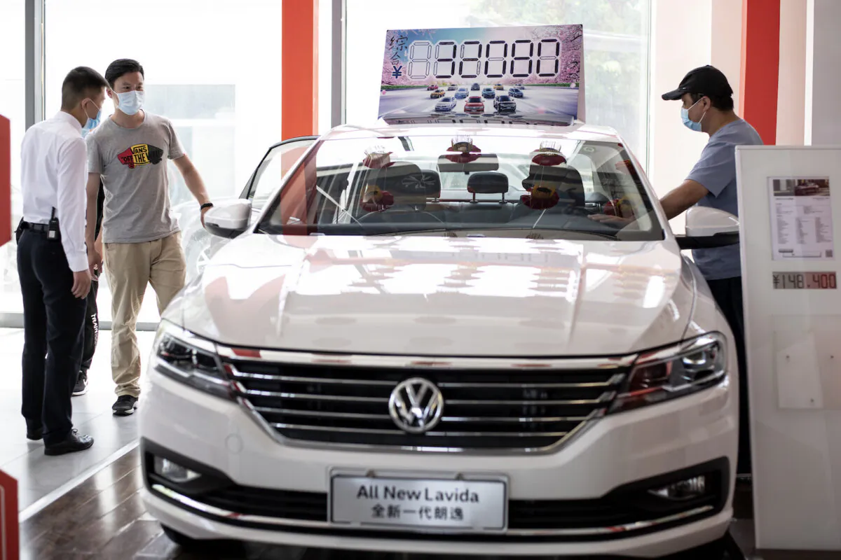 People looking at a Volkswagen car on display at a showroom in Beijing on May 10, 2020. (Noel Celis/AFP via Getty Images)