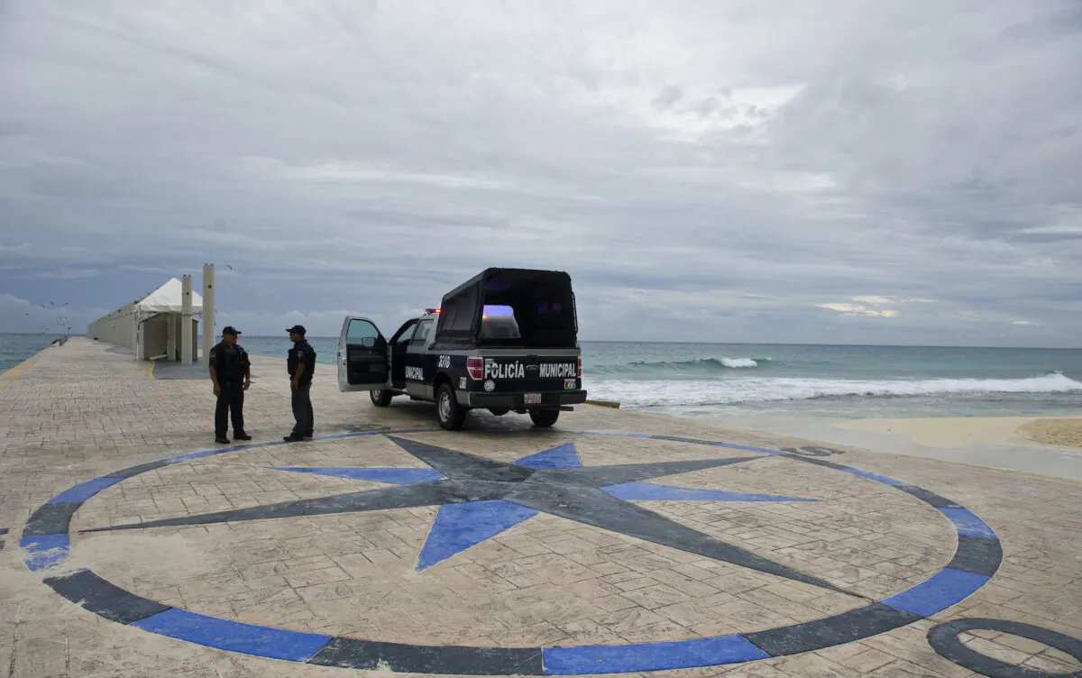 Police stand guard at the port of Playa del Carmen, Quintana Roo State, Mexico, before the arrival or Tropical Storm Rina, on October 27, 2011.  Hurricane Rina weakened Thursday to a tropical storm hours before it was expected to crash into tourist resorts dotting Mexico's Caribbean coast like Cancun and Playa del Carmen, US experts said.  AFP PHOTO/RONALDO SCHEMIDT (Photo credit should read Ronaldo Schemidt/AFP via Getty Images)