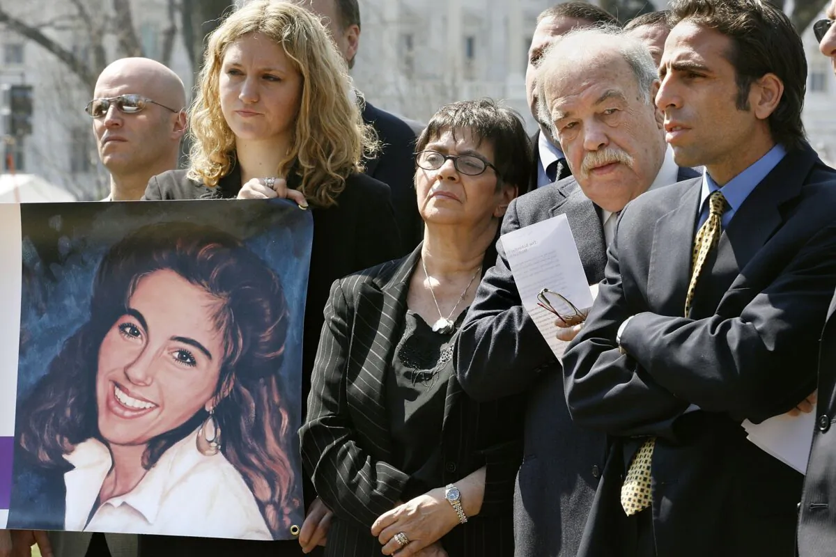 Terri Schindler Schiavo's family (R-L) brother Bobby Schindler and parents Mary and Robert Schindler hold a media conference on Capitol Hill to announce the official launch of The Terri Schindler Schiavo Foundation as National Right to Life PAC employee Elizabeth Maier holds a banner with Terri's photograph, in Washington on March 30, 2006. After living in what doctors called a persistent vegetative state for years, Terri Schiavo died March 31, 2005, after her feeding tube was removed two weeks earlier. Bobby Schindler and his family were against the removal of the feeding tube and wanted to keep Terri alive. The not-for-profit foundation has stated that its mission is to "ensure the rights of disabled, elderly, and vulnerable citizens against care rationing, euthanasia and medical killing." (Chip Somodevilla/Getty Images)