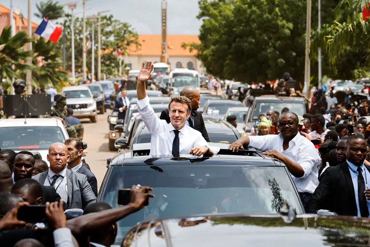 TOPSHOT - French President Emmanuel Macron and Guinea-Bissau's President Umaro Sissoco Embalo (R) wave to the crowd through the roof of a car in Bissau, on July 28, 2022. (Photo by Ludovic MARIN / AFP) (Photo by LUDOVIC MARIN/AFP via Getty Images)