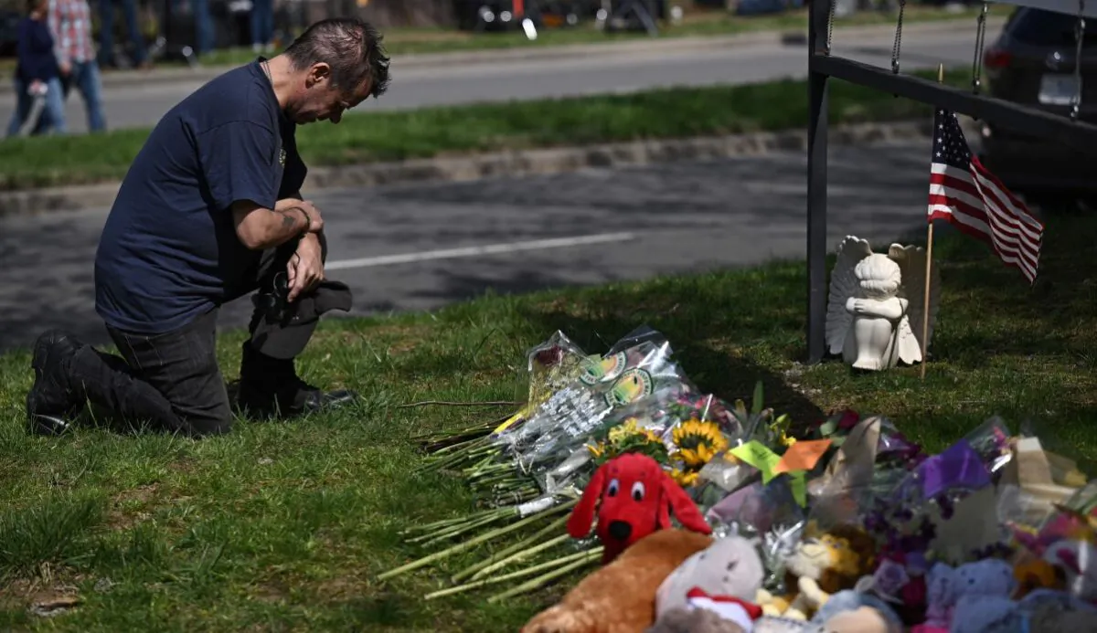 Bart Pike says a prayer after placing an angel and an American flag at a makeshift memorial for victims by the Covenant School building at the Covenant Presbyterian Church following a shooting, in Nashville, Tenn., March 28, 2023. (Brendan Smialowski/AFP via Getty Images)