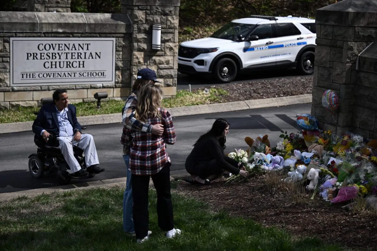 People pay their respects at a makeshift memorial for victims at The Covenant School building at the Covenant Presbyterian Church following a shooting, in Nashville on March 28, 2023. (Brendan Smialowski/AFP via Getty Images)