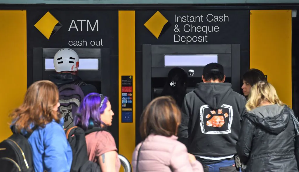 People queue for ATM machines outside a branch of the Commonwealth Bank in Melbourne on August 8, 2018. - Australia's biggest bank, the Commonwealth, posted a slide in annual profits on August 8, capping a tumultuous year for a troubled lender which has been rocked by scandals and board upheaval. (Photo by William WEST / AFP) (Photo by WILLIAM WEST/AFP via Getty Images)