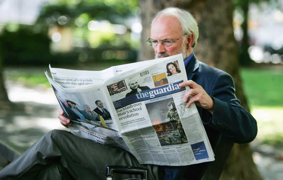 A man reads a copy of The Guardian newspaper in London, England, on Sept. 12, 2005. (Scott Barbour/Getty Images)