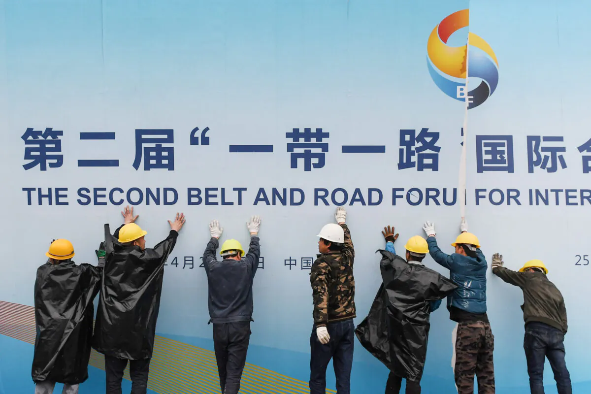 Workers take down a Belt and Road Forum panel outside the venue of the forum in Beijing on April 27, 2019. - Chinese President Xi Jinping urged dozens of world leaders on April 27 to reject protectionism and invited more countries to participate in his global infrastructure project after seeking to ease concerns surrounding the programme. (Photo by GREG BAKER / AFP) (Photo credit should read GREG BAKER/AFP via Getty Images)