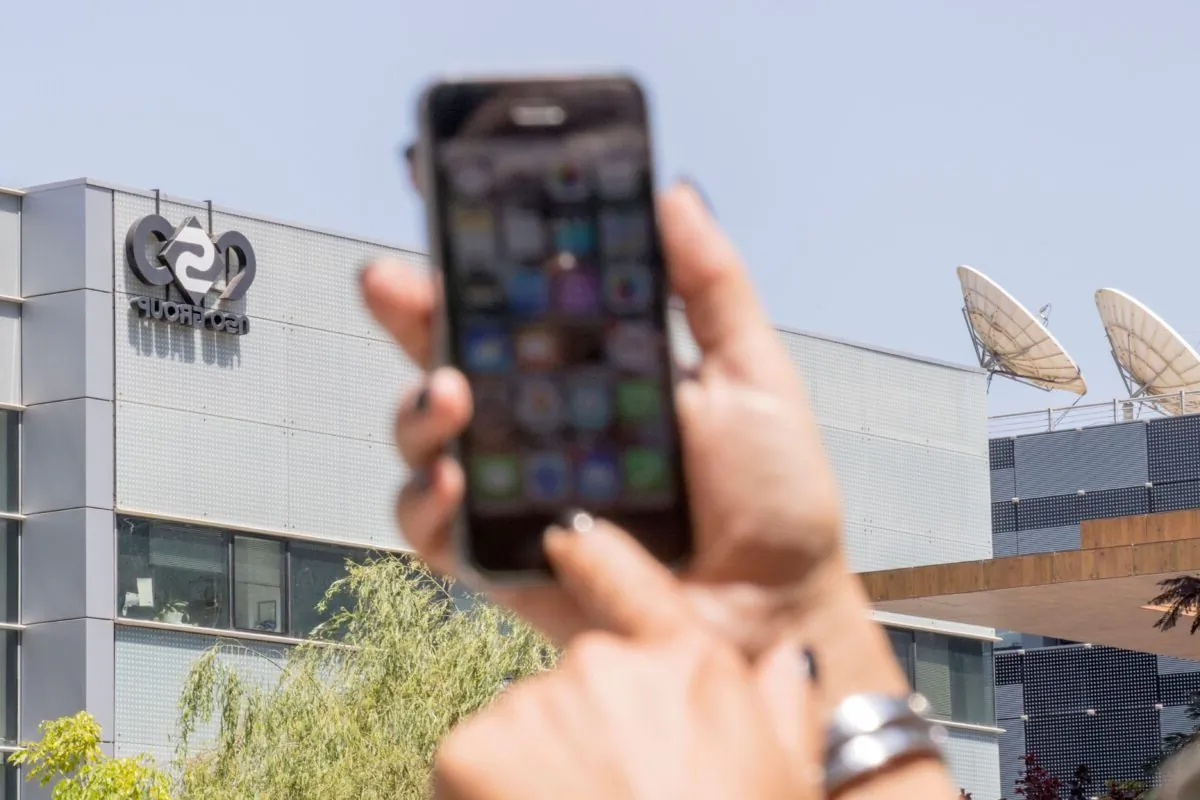An Israeli woman uses her iPhone in front of the building housing the Israeli NSO group in Herzliya, near Tel Aviv, on Aug. 28, 2016.  (Jack Guez/AFP via Getty Images)