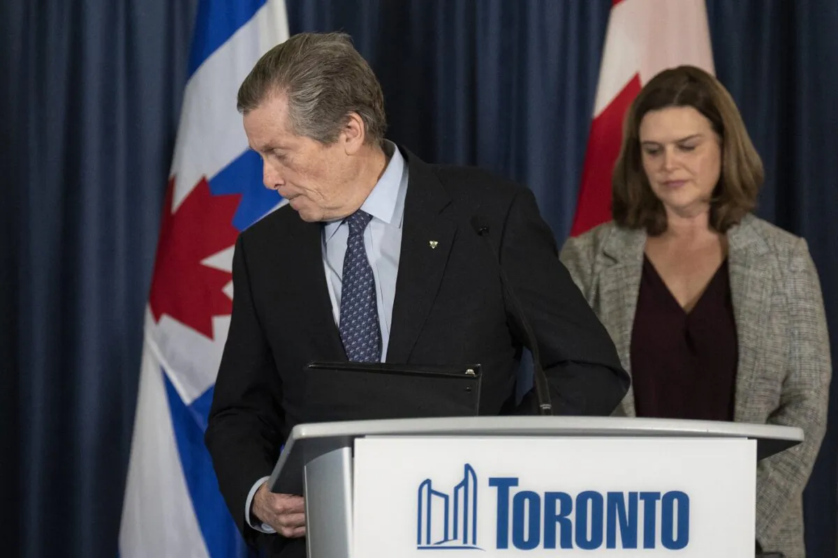 John Tory walks away from the Toronto city hall podium, as deputy mayor Jennifer McKelvie looks on, Feb. 17, 2023. (The Canadian Press/Chris Young)