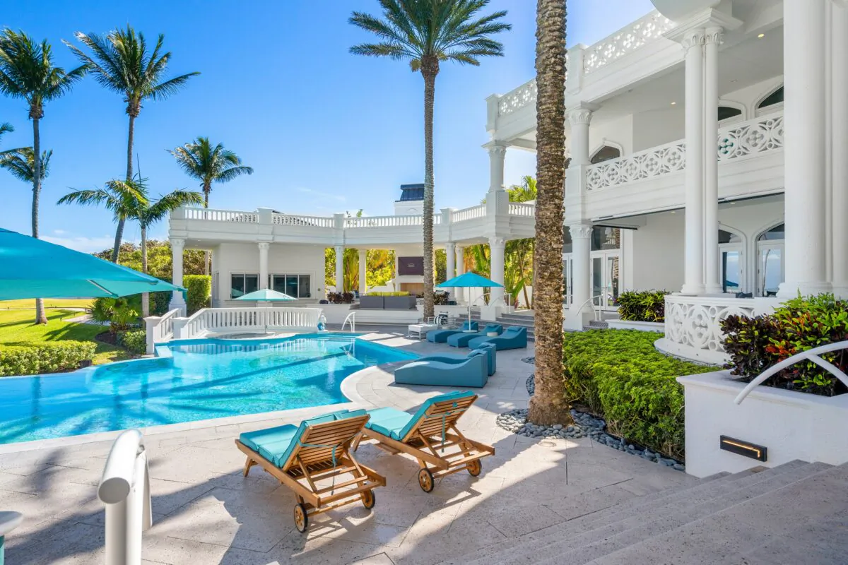 Easily accessed from the residence’s common areas, the pool features Venetian glass and 14-karat accents and is surrounded by lounge seating, with a large swath of lawn beyond. (Courtesy of James Northen / ONE Sotheby's International Realty)