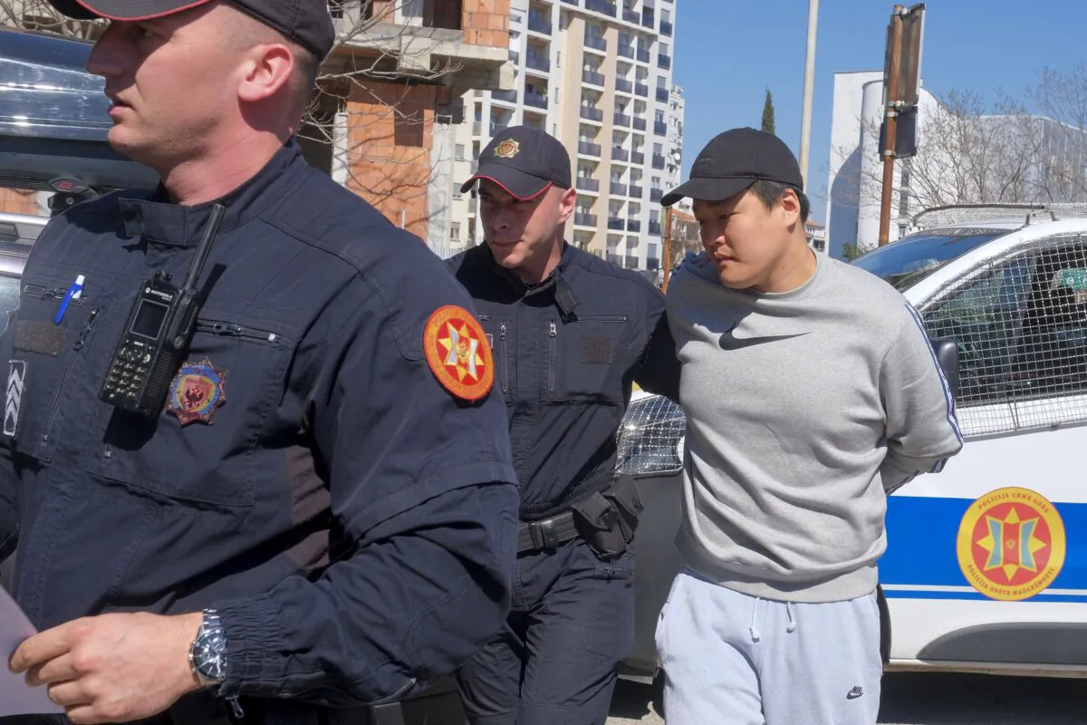 Montenegrin police officers escort an individual who is believed to be one of the most wanted fugitives, South Korean citizen, Terraform Labs founder Do Kwon in Montenegro's capital Podgorica on March 24, 2023. (Risto Bozovic/AP Photo)