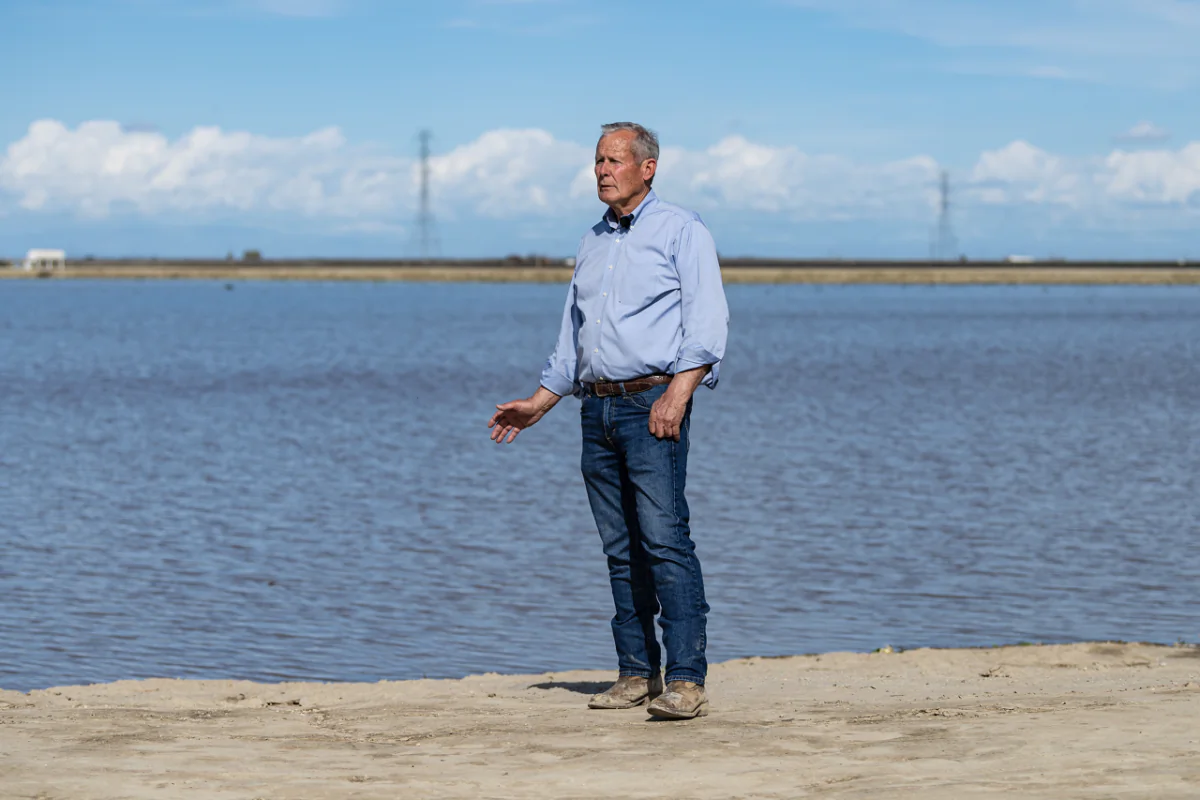 Don Cameron, general manager of Terranova Ranch, poses as recharge water stands in this fallow field at Terranova in Fresno County, on March 13, 2023. (Andrew Innerarity/California Department of Water Resources via AP)