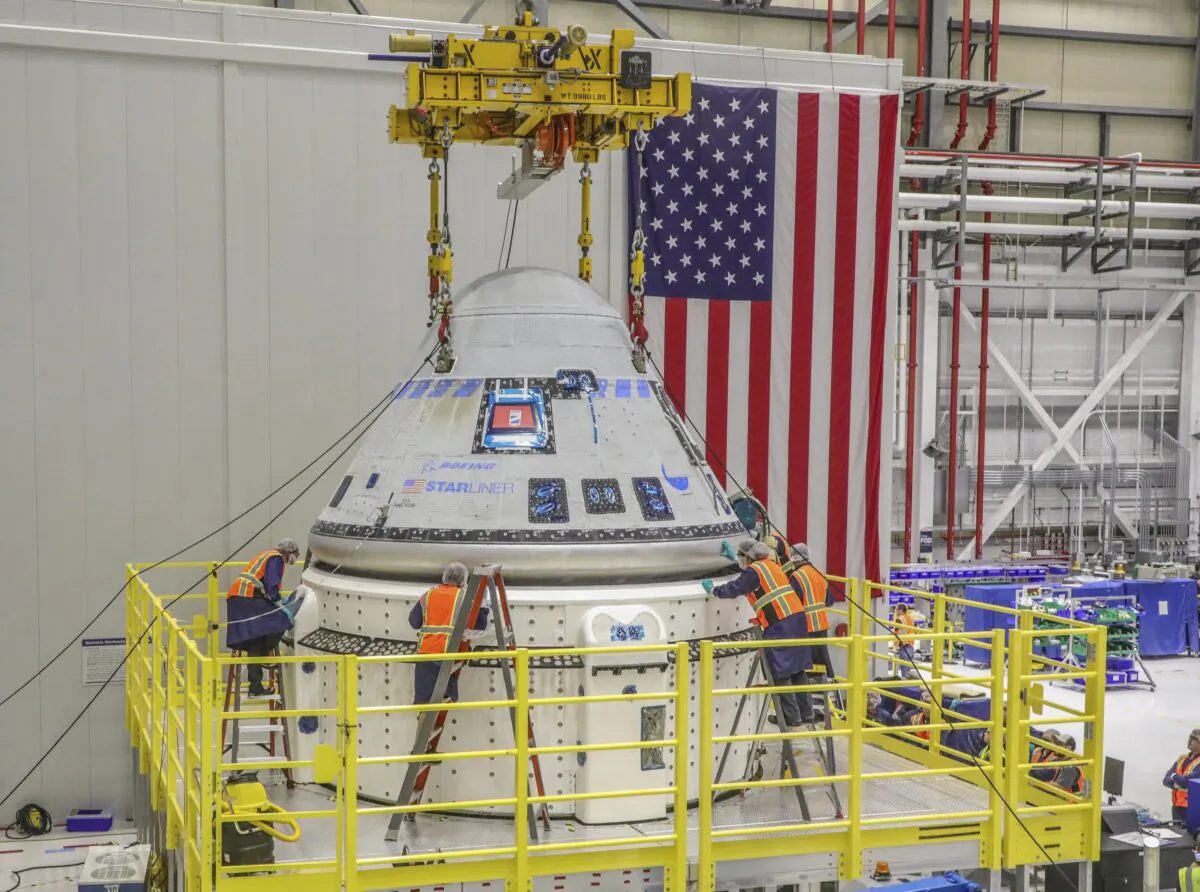 Technicians work on the Starliner spacecraft at the Kennedy Space Center in Fla. on Jan. 19, 2023, in preparation for NASA's Boeing Crew Flight Test. (John Grant/Boeing via AP)