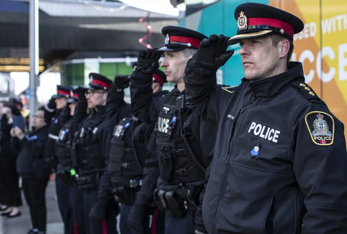 City police salute during the procession for Edmonton Police Service constables Travis Jordan and Brett Ryan in Edmonton, on March 27, 2023. (The Canadian Press/Jason Franson)