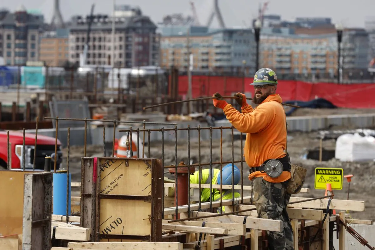 A construction worker prepares a recently poured concrete foundation in Boston, Mass., on March 17, 2023. (Michael Dwyer/AP Photo)