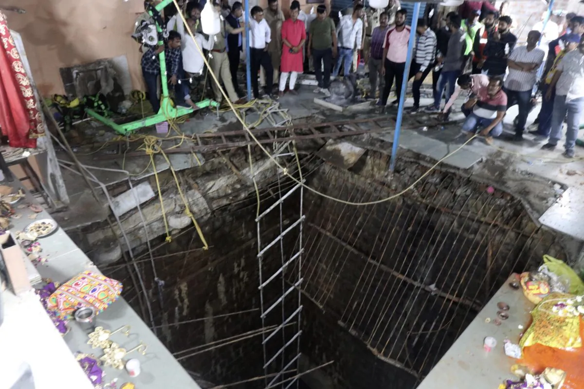 People stand around a structure built over an old temple well that collapsed Thursday as a large crowd of devotees gathered for the Ram Navami Hindu festival in Indore, India, on March 30, 2023. (AP Photo)
