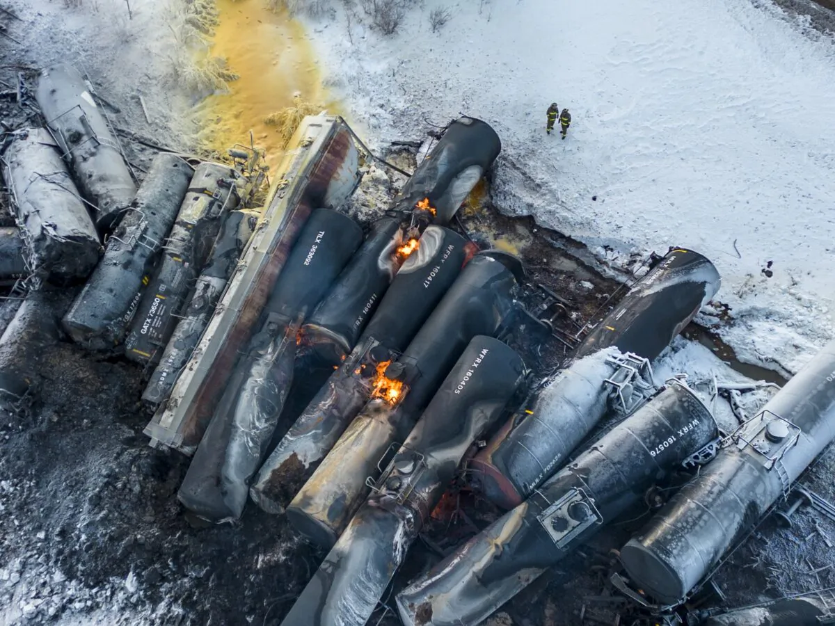 Firefighters stand near piled up train cars, near Raymond, Minn., on March 30, 2023, the morning after a BNSF freight train derailed. (Kerem Yücel/Minnesota Public Radio via AP)