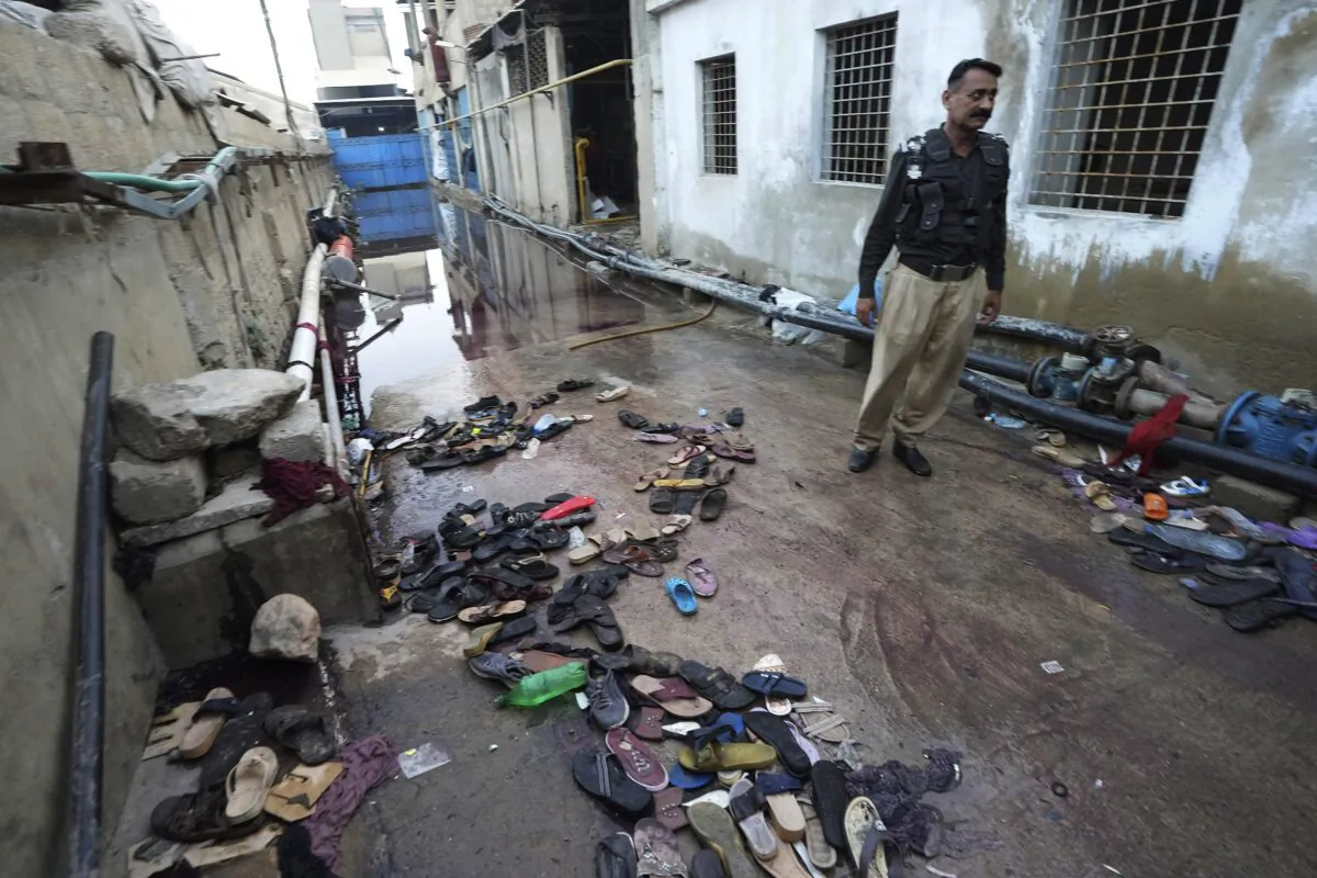 A police officer examines the site of stampede in Karachi, Pakistan, on March 31, 2023. (Fareed Khan/AP Photo)