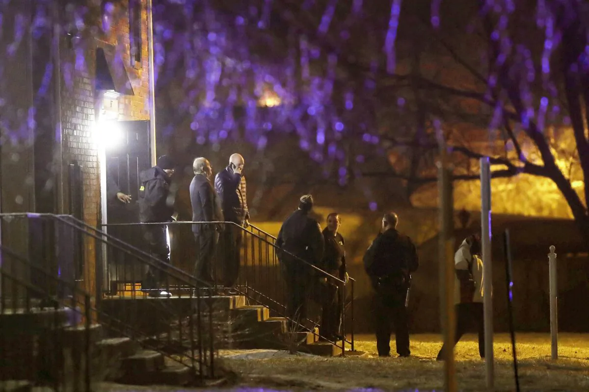 Officers walk out of the apartment complex where four people, one woman and three men, were found dead in Indianapolis on Feb. 5, 2020. (Grace Hollars/The Indianapolis Star via AP)