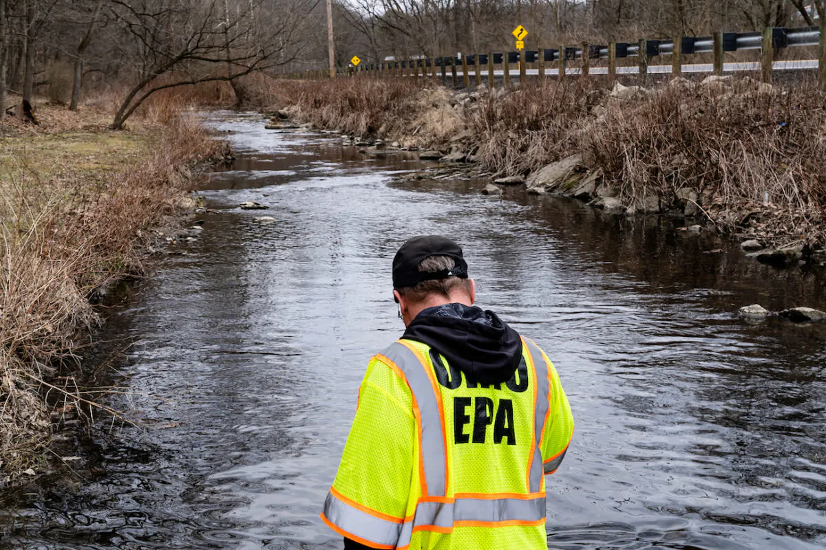 Ron Fodo of Ohio EPA Emergency Response looks for signs of fish in Leslie Run creek and also agitates the water to check for chemicals that have settled at the bottom following a train derailment that is causing environmental concerns in East Palestine, Ohio, on Feb. 20, 2023. (Michael Swensen/Getty Images)