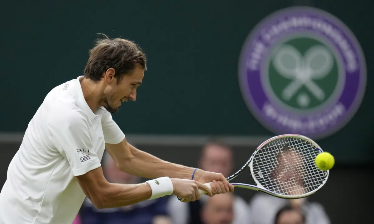 Russia's Daniil Medvedev plays a return to Poland's Hubert Hurkacz during the men's singles fourth round match on day eight of the Wimbledon Tennis Championships in London on July 6, 2021. (Kirsty Wigglesworth/AP Photo)