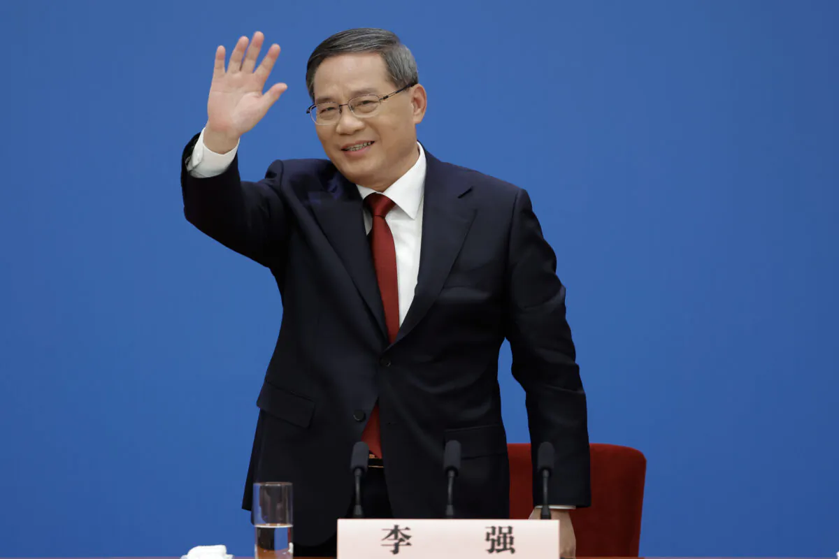 New Chinese Premier Li Qiang waves at his first press conference at the Great Hall of the People in Beijing on March 13, 2023. (Lintao Zhang/Getty Images)