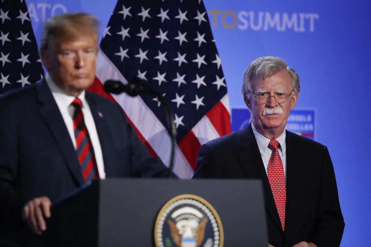 Then-President Donald Trump, flanked by then-national security adviser John Bolton, speaks to the media at a press conference. (Sean Gallup/Getty Images)