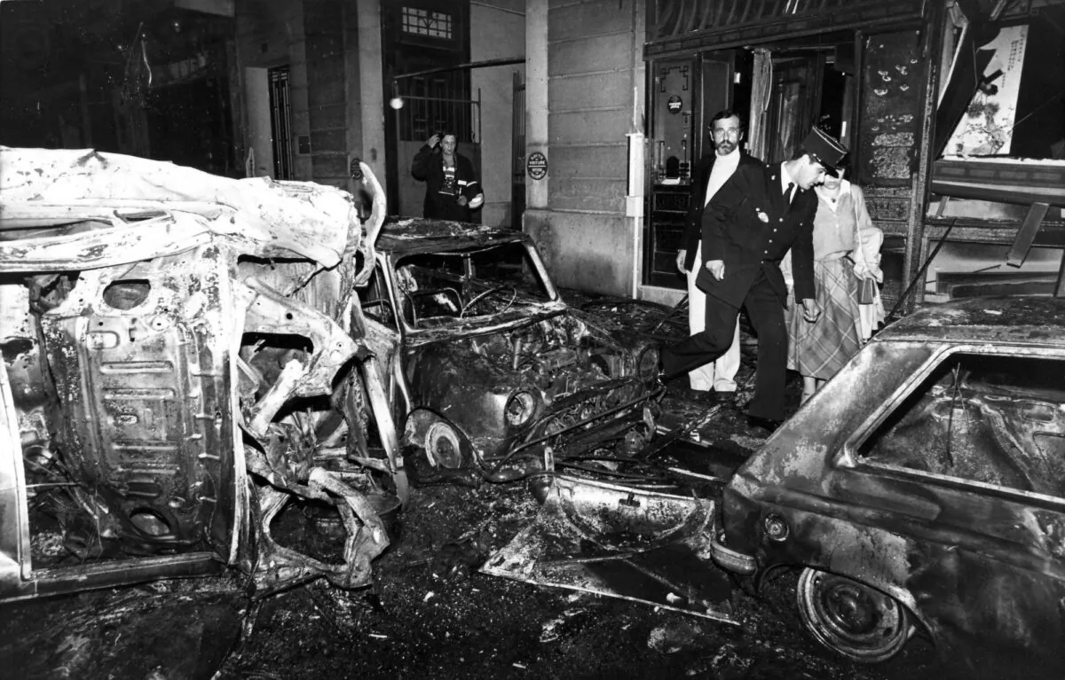 A police officer walks at the scene after the bombing of the Copernic street synagogue, in Paris, that killed 4 people on Oct. 3, 1980. (Remy de la Mauviniere/AP Photo)