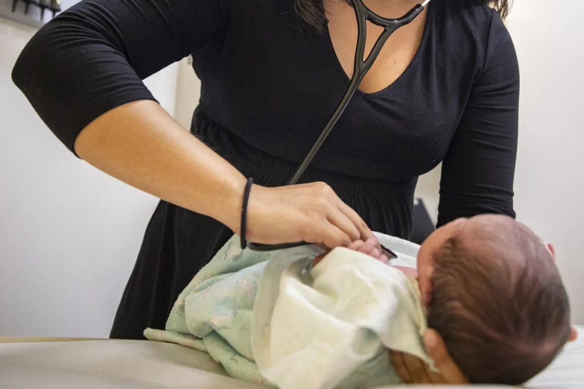 A pediatrician examines a newborn baby in her clinic in Chicago on Aug. 13, 2019. (The Canadian Press/AP-Amr Alfiky)
