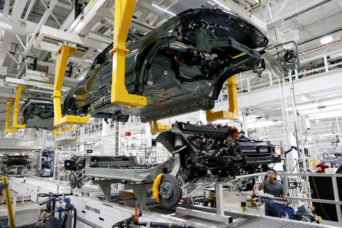 An employee works on an assembly line at startup Rivian Automotive's electric vehicle factory in Normal, Ill., on April 11, 2022. (Kamil Krzaczynski/Reuters)