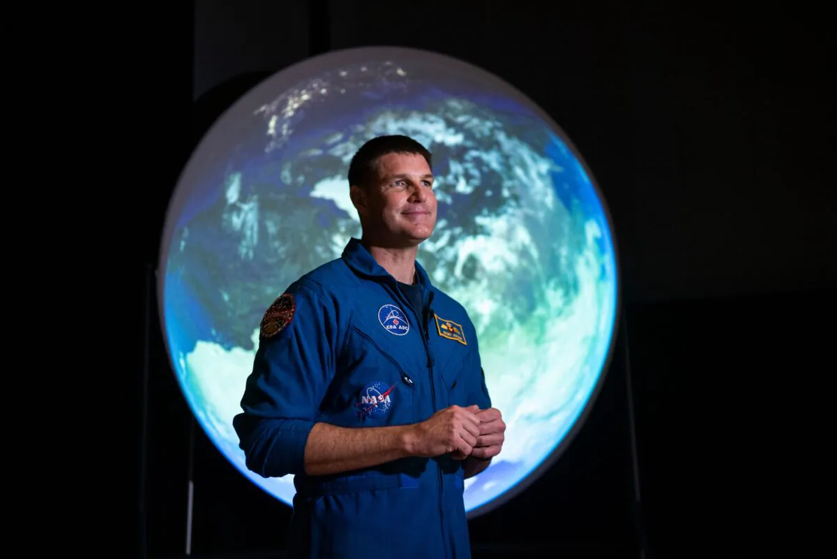 Canadian Space Agency astronaut Jeremy Hansen stands in front of a display as he participates in an interview at the opening of Earth in Focus: Insights from Space, a new exhibition at the Canada Science and Technology Museum in Ottawa, on Nov. 26, 2021. (Justin Tang/The Canadian Press)