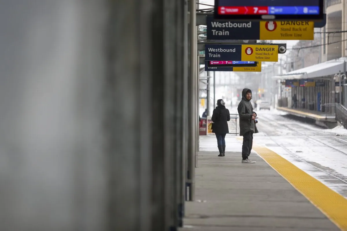 Two passengers wait for a transit train in Calgary on March 18, 2020. (The Canadian Press/Jeff McIntosh)