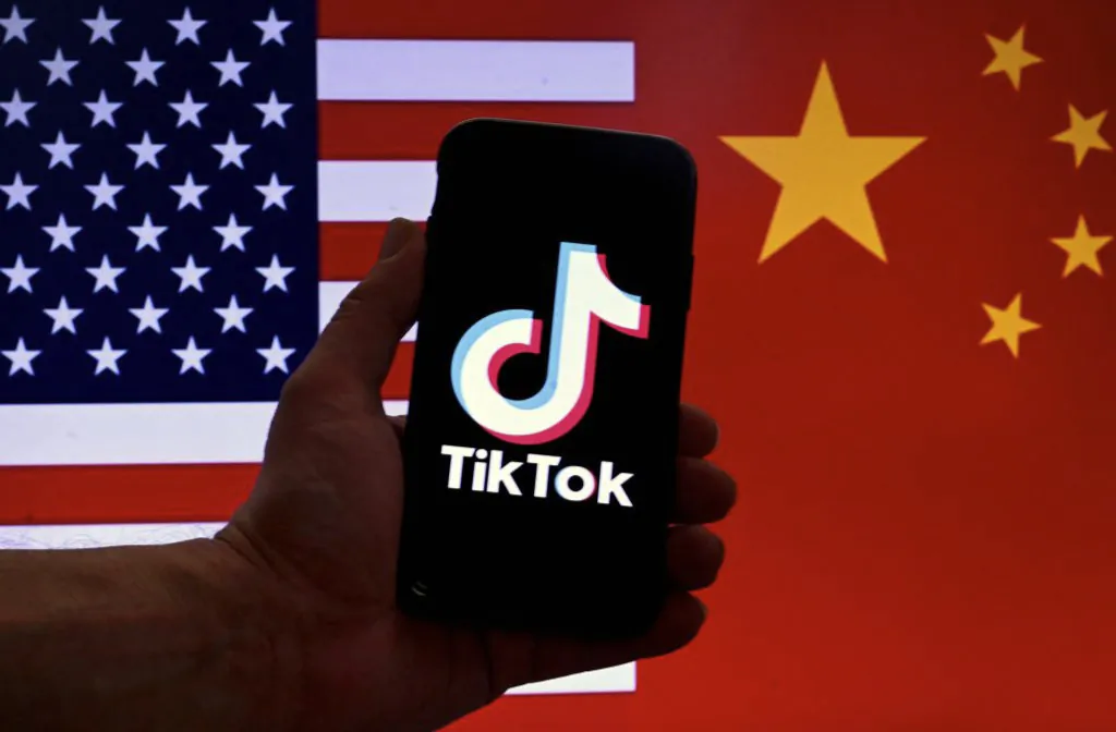 The social media application logo for TikTok is displayed on the screen of an iPhone in front of a U.S. flag and Chinese flag background in Washington on March 16, 2023. (Olivier Douliery/AFP via Getty Images)