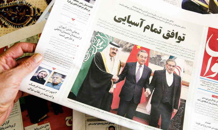 A man holds a local newspaper reporting on the China-brokered deal between Iran and Saudi Arabia to restore ties, in the Iranian capital Tehran on March 11, 2023. (Atta Kenare/AFP via Getty Images)