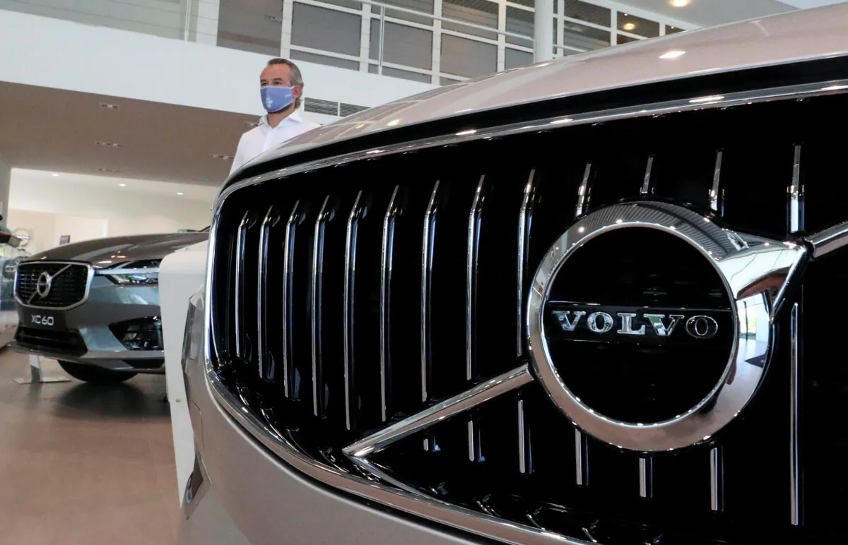 An employee at a Volvo car dealer is seen in a showroom in Brussels on May 28, 2020. (Yves Herman/Reuters)