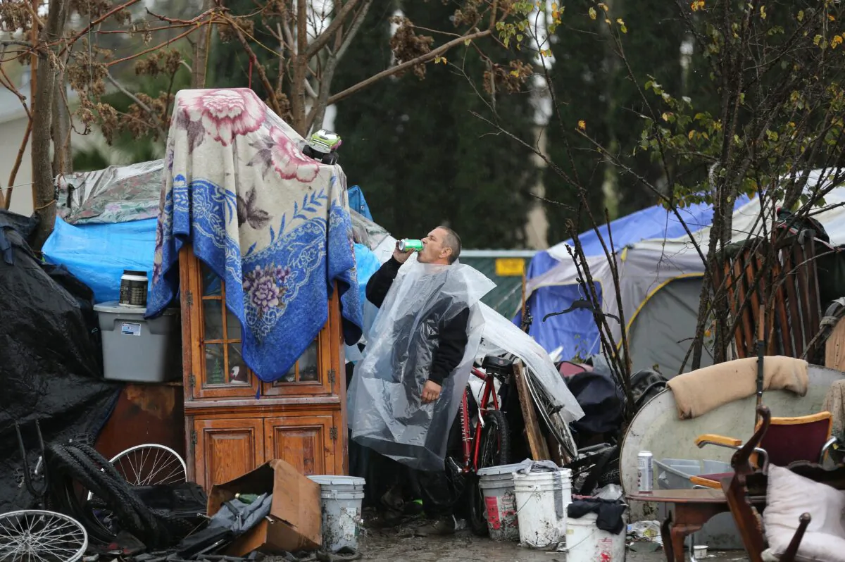 A man gulps down a drink at the Silicon Valley homeless encampment known as "The Jungle" in San Jose, Calif., on, Dec. 3, 2014. (Josh Edelson/AFP via Getty Images)