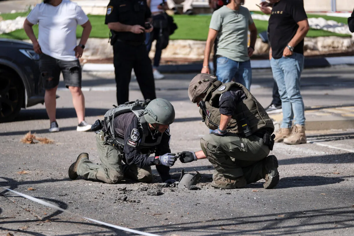 Israeli security personnel check the remains of a rocket in Shlomi, northern Israel, on April 6, 2023. (Fadi Amun/Reuters)