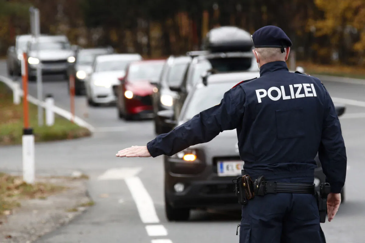 An Austrian police officer gestures towards car drivers during a traffic control at the Südring in Klagenfurt, Austria, on Nov. 15, 2021, during the ongoing coronavirus (Covid-19) pandemic. Austria Out (Gert Eggenberger/APA/AFP via Getty Images)