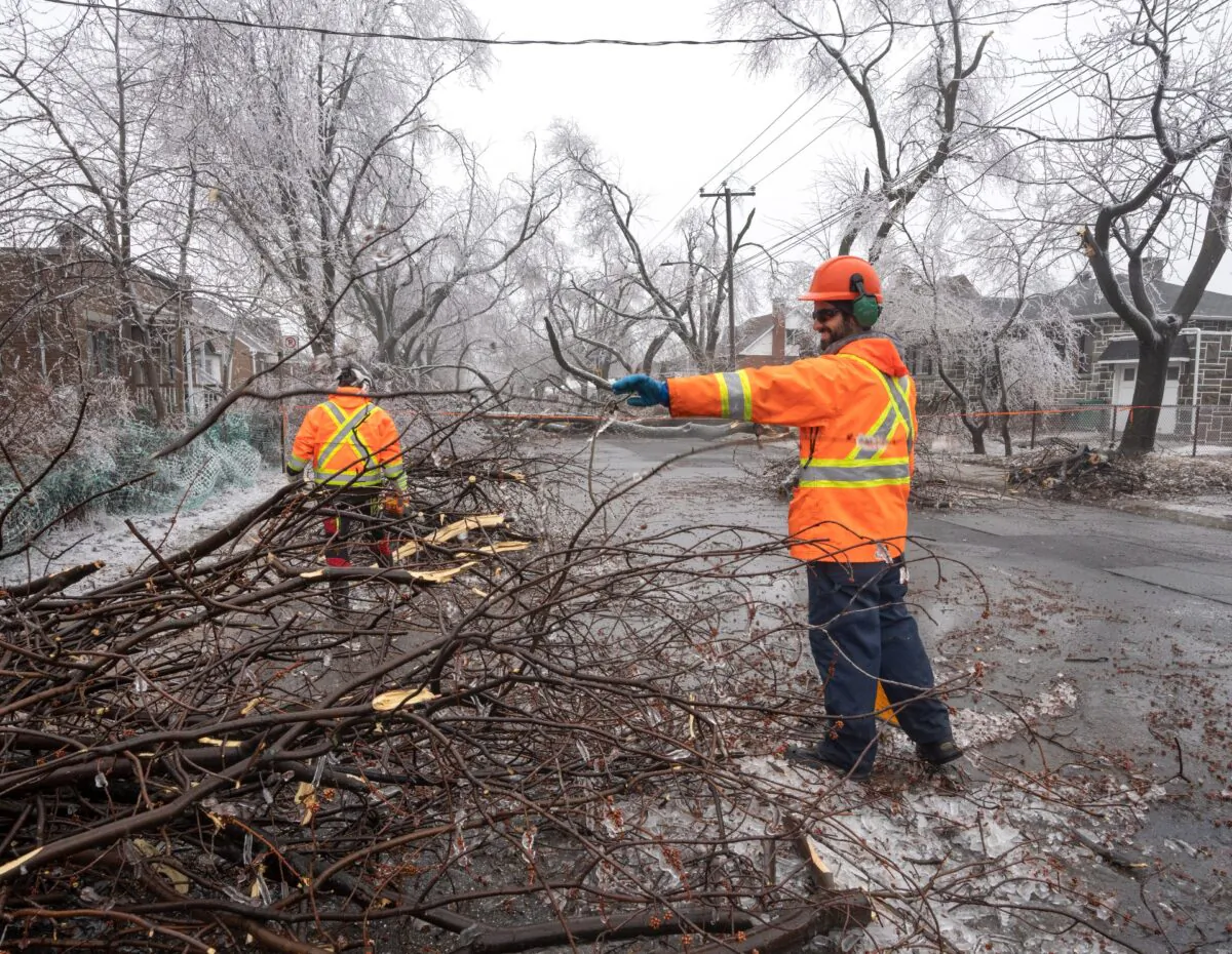 City workers clear fallen branches in Montreal on April 6, 2023, after an ice storm which initially left over a million customers without power.  (Ryan Remiorz/The Canadian Press)