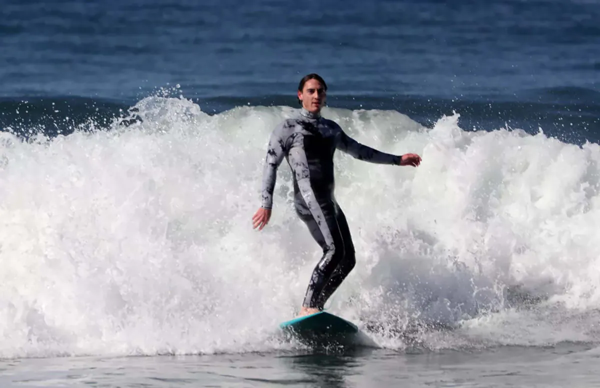 Lawrence Doherty catches a wave in Malibu during the first part of a “California Double” trip — surfing and snowboarding in one day. (Luis Sinco/Los Angeles Times/TNS)
