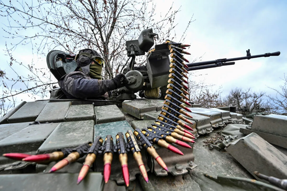A Ukrainian serviceman checks a machine gun of a tank after loading an ammunition belt during a military training exercise near a frontline in Zaporizhzhia Region, Ukraine, on March 29, 2023. (Stringer/Reuters)
