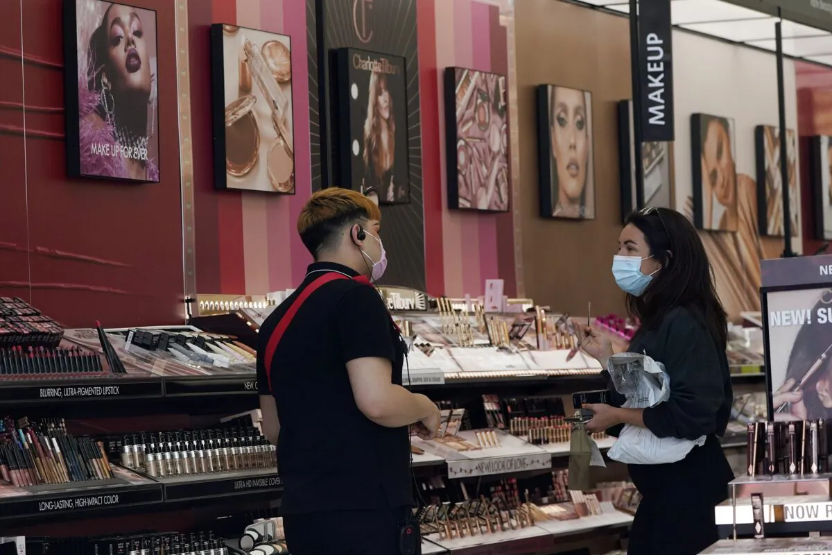 A worker (L) tends to a customer at a cosmetics shop in Los Angeles on May 20, 2021. (Marcio Jose Sanchez/AP Photo)