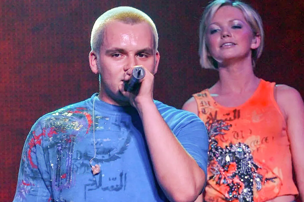 Paul Cattermole and fellow band mate Hannah looks on as they perform with pop group S Club 7 on stage at Wembley Arena in London on Feb. 14, 2002. (Yui Mok/PA via AP)