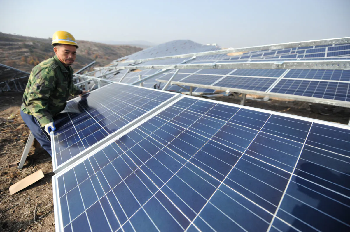 A worker installing polycrystalline silicon solar panels as a  terrestrial photovoltaic power project started in Guanshui Town of Muping District on Nov. 17, 2015, in Yantai, Shandong Province, China. (VCG/VCG via Getty Images)