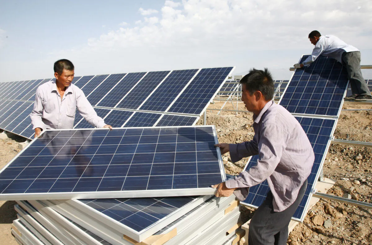 Construction workers install solar panels at Hami Solar Power Station in Hami, China's Xinjiang region, on Aug. 22, 2011. (VCG/VCG via Getty Images)