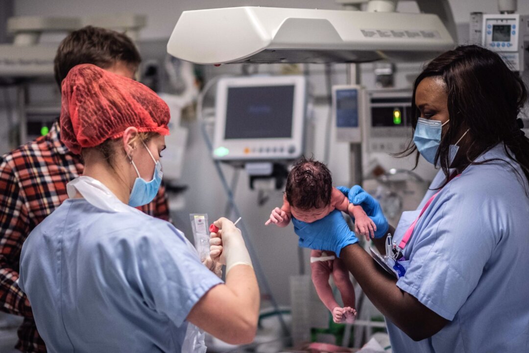 Medical staff members take care of a newborn baby in the paediatric ward of a hospital in this file photo taken on Nov. 17, 2020. (Martin Bureau/AFP via Getty Images)